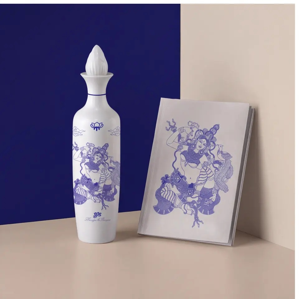 Lotus Gin bottle beside a cobalt and porcelain art book